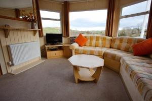 a living room with a couch and a tv at Bella May Mobile Home in Ballintra