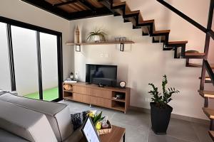 a living room with a couch and a television at Amora Maria Residencial in Cascavel