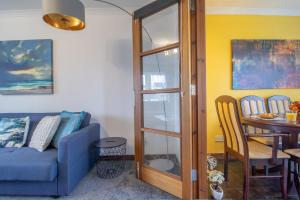 a living room with a blue couch and a table at Ideal Contractor Stay 2-Bed Near Glasgow Fort in Garthamlock
