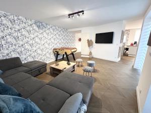 a living room with a couch and a table at Jolie maison familiale 14 personnes in Trélazé