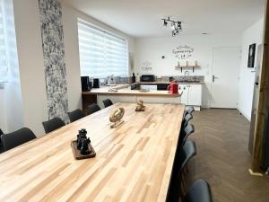 a large wooden table in a room with a kitchen at Jolie maison familiale 14 personnes in Trélazé