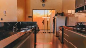 a kitchen with a sink and a refrigerator at Casa incrivel em Bebedouro com piscina e lazer in Bebedouro