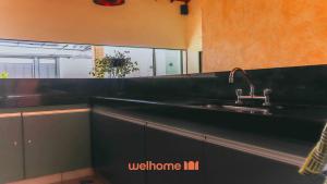 a kitchen with a sink and a black counter top at Casa incrivel em Bebedouro com piscina e lazer in Bebedouro