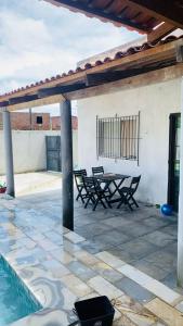 a patio with a table and chairs and a pool at casa de praia em carne de vaca Pe in Carne de Vaca