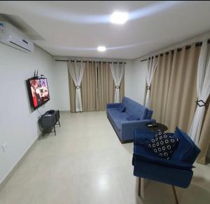 a living room with a blue couch and a tv at Casa em Capitolio-MG in Capitólio