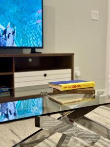 a group of books sitting on a glass table in front of a tv at Superb Luxurious 3Br in the Heart of Providence in Providence