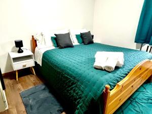 a bedroom with a bed with green sheets and pillows at Casa Bucaneve in Camigliatello Silano