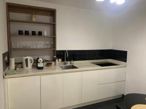 a kitchen with white cabinets and a sink at Paradiso Apartments - 1 BDR in Oranjestad