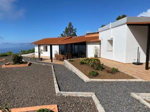 a white house with a table and chairs in front of it at helios casa vacacional in Puntagorda
