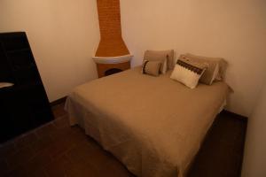a bedroom with a bed with pillows on it at La Casona de Ciudad Vieja in Ciudad Vieja +1 photo