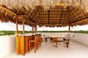 ein Restaurant mit einem Tisch, Stühlen und einem Strohdach in der Unterkunft Mario's house 2 beautiful rooftop pool in Cozumel