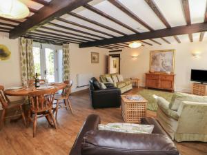 a living room filled with furniture and a table at Barn Cottage in Buxton