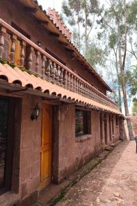 an old brick building with a door and a porch at Posadas del Castillo del Titicaca in Vencalla +17 photos