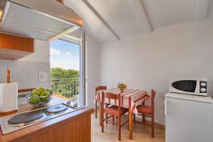 a kitchen with a table and a window with a view at Apartmani Tony in Banjole +13 photos