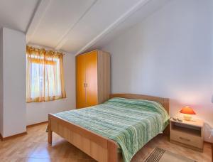 a small bedroom with a bed and a cabinet at Apartmani Tony in Banjole