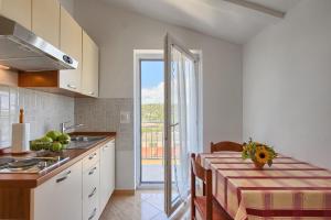 a kitchen with a table and a dining room at Apartmani Tony in Banjole