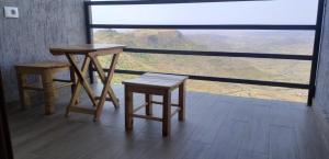 a room with two tables and two stools and a view at Halle Hotel - Lalibela in Lalībela