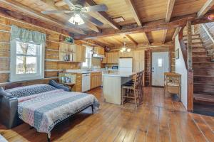 1 dormitorio en una cabaña de madera con 1 cama y cocina en Historical Log Cabin on 80 Acres in Hartford!, en Hartford