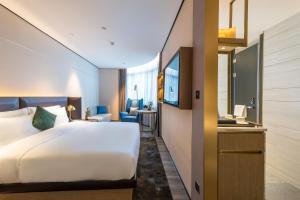 Postel nebo postele na pokoji v ubytování Echarm Plus International Hotel Ouzhuang Metro Station Branch - Free Deliver Service to Canton Fair Complex During Canton Fair Period