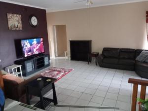 a living room with a couch and a tv at Sole Sands Bliss Guesthouse in Meer en See