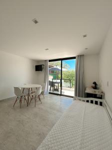 a white room with a table and chairs and a view at La bardot boutique Pousada in Búzios +91 photos