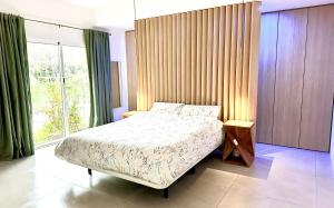 a bedroom with a bed and a large window at Palm Garden Valencia in Bétera