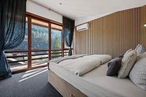 a bedroom with a bed with a large window at Luxus-Gästehaus mit Sauna, Kamin & exklusivem Paarbereich in Neubulach +34 photos