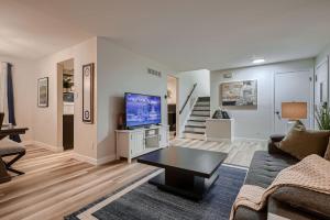 a living room with a couch and a tv at The Arvada Retreat with HotTub, Games, Gym and Lounge in Arvada