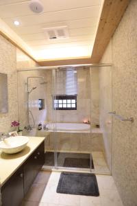 a bathroom with a shower and a sink and a tub at Aria's Home in Hualien City +53 photos