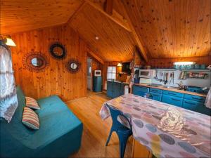 Una cocina con una mesa y un sofá en una habitación. en Le petit chalet de Cabourg, en Cabourg
