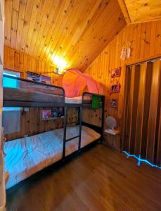 2 literas en una habitación con techo de madera en Le petit chalet de Cabourg, en Cabourg