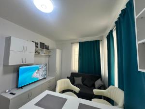 a living room with a couch and a television at AlyStar apartament in Mamaia Sat/Năvodari