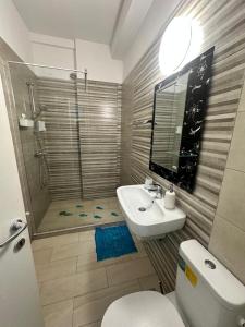 a bathroom with a toilet and a sink and a shower at AlyStar apartament in Mamaia Sat/Năvodari +9 photos