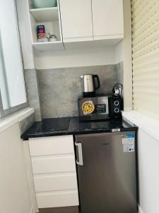 a small kitchen with a microwave and a refrigerator at TAJ house center altea #1 in Altea