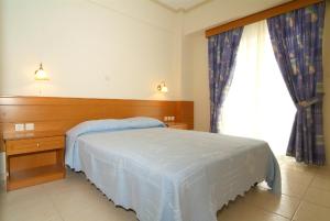 a bedroom with a bed and a large window at Sagittarius Apartments in Tigaki