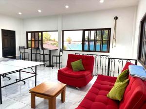 a living room with a red couch and a table at Bonita Quinta Familiar in Itzamatitlán