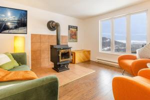 a living room with a wood stove in it at Studio Entre Ciel et Fleuve in Petite-Rivière-Saint-François