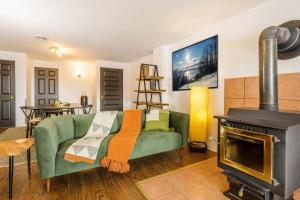 ein Wohnzimmer mit einer grünen Couch und einem Kamin in der Unterkunft Studio Entre Ciel et Fleuve in Petite-Rivière-Saint-François + 3 Fotos