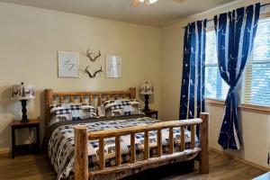 a bedroom with a wooden bed with blue curtains at Mountain View Retreat in Show Low