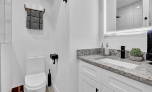 a white bathroom with a toilet and a sink at The Business Bungalow-5 Mins From Airport in Atlanta +22 photos