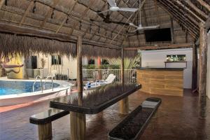 ein Resort mit einem Pool und einer Badewanne mit einem TV in der Unterkunft Casa de Mario 4 Beautiful house with a huge pool in Cozumel