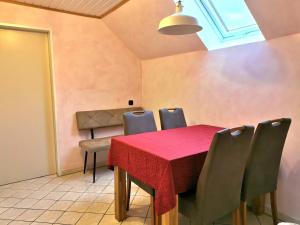 a dining room with a red table and chairs at Dorfidylle Wiesens in Aurich