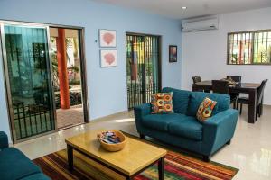 ein Wohnzimmer mit einem blauen Sofa und einem Tisch in der Unterkunft Casa de Mario 4 Beautiful house with a huge pool in Cozumel