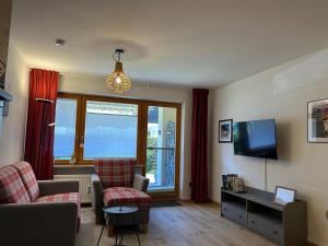 Una sala de estar con un sofá y un televisor. en Ferienwohnung Lieblingsplatzl mit Garten, en Oberaudorf