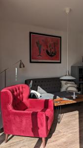 a living room with a red couch and a table at Ferienwohnung im Kontor Penzlin in Penzlin +27 photos