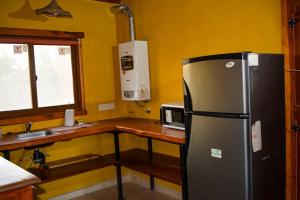 una cocina con refrigerador de acero inoxidable y encimera en Turismo Aparts Cabaña 4, en Villa Giardino