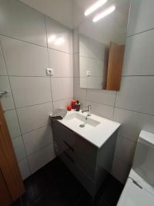 un bagno bianco con lavandino e specchio di Cozy and Bright Apartment a Machico Altre 30 foto