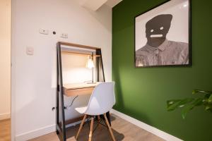 a room with a green wall with a desk and a mirror at Bohemian Barranco Apartments by Geko in Lima