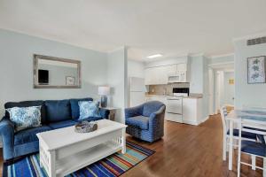 a living room with a blue couch and a table at Savannah Beach & Racquet Club 324A in Tybee Island