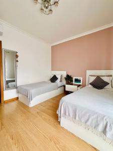 a bedroom with two beds and a chandelier at Casa Sam Lagos in Lagos